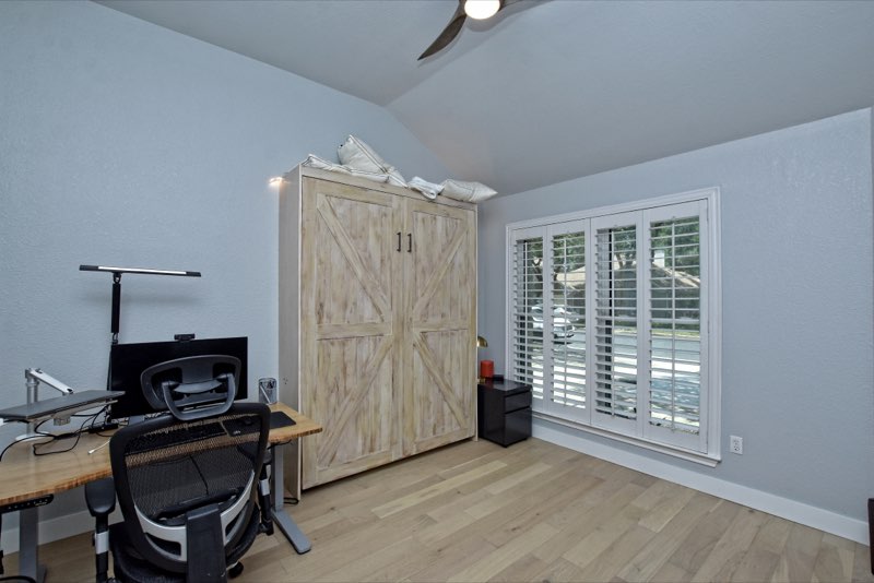 Home office with plantation shutters and vaulted ceiling